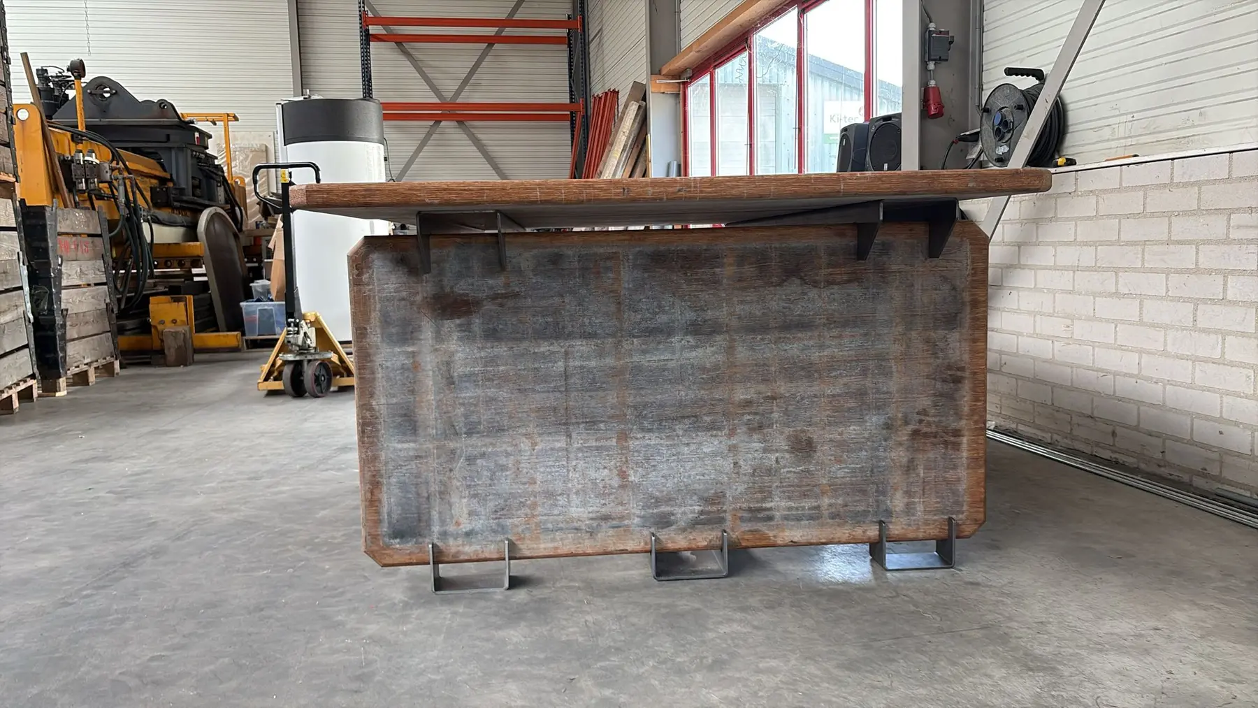 Front view of a large table made from recovered timber and fabricated steel